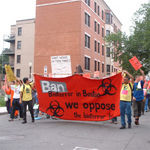 Community members marching with a banner opposing the BU biolab